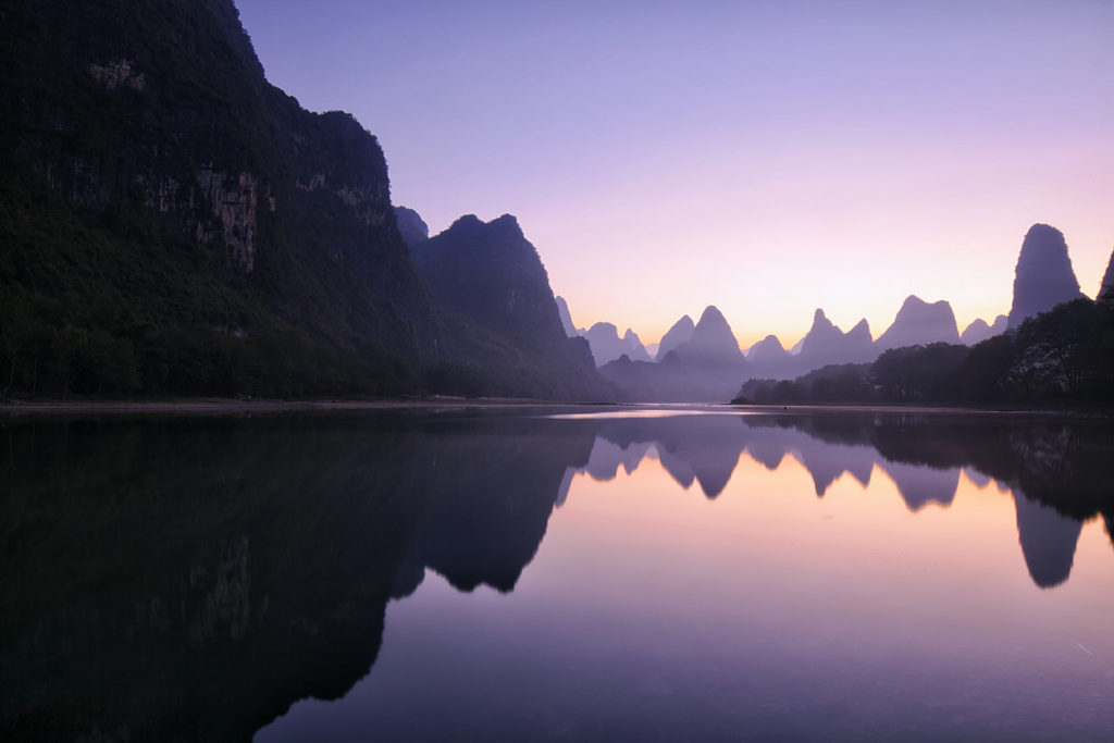 Experience remarkable Chinese sights like these mountains reflecting in a Guilin Lake when you take a tailor-made holiday with Alfred&.