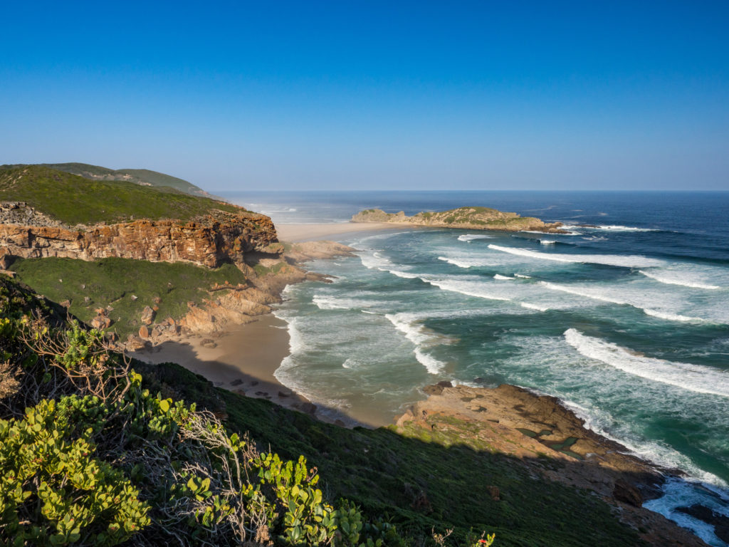 Experience extraordinary landscape like this sweeping shoreline in Plettenberg, South Africa, when you take a tailor-made holiday with Alfred&.
