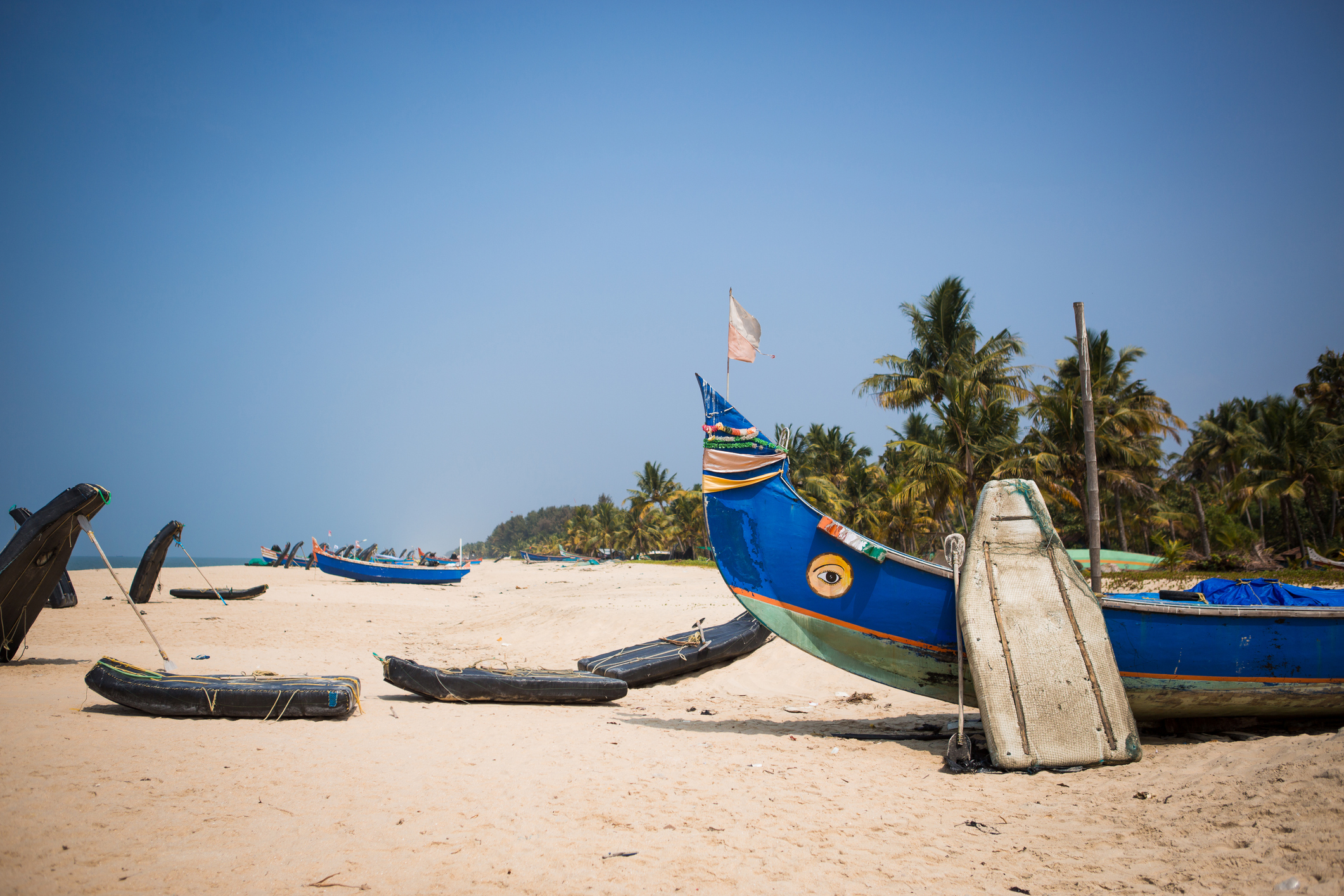 Witness remarkable Indian sights like this white-sand beach dotted with fishing boats in Mararikulam when you take a tailor-made holiday with Alfred&.