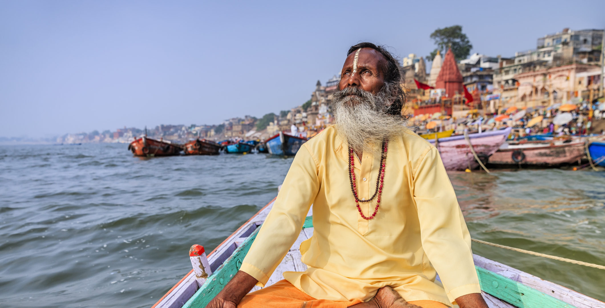 Meet friendly Indian locals like this tour guide meditating in a boat on the Ganges, Varanasi when you take a tailor-made holiday with Alfred&.