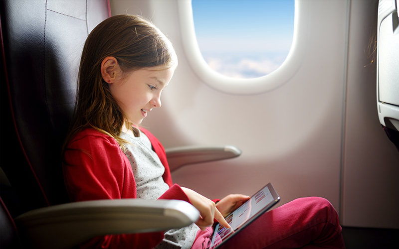 Child with a tablet on a flight